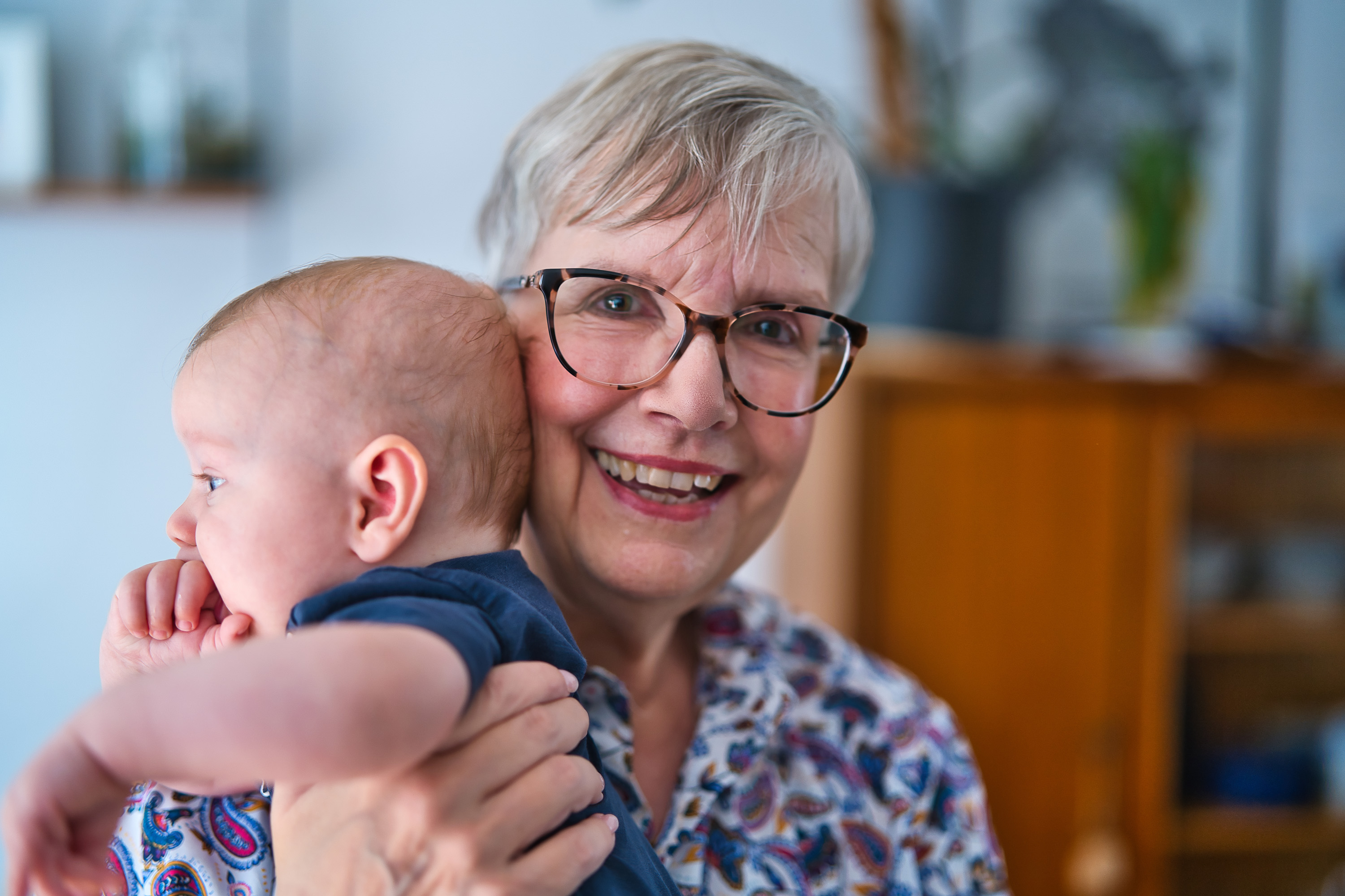 Eine ältere Frau hält ein Baby im Arm 